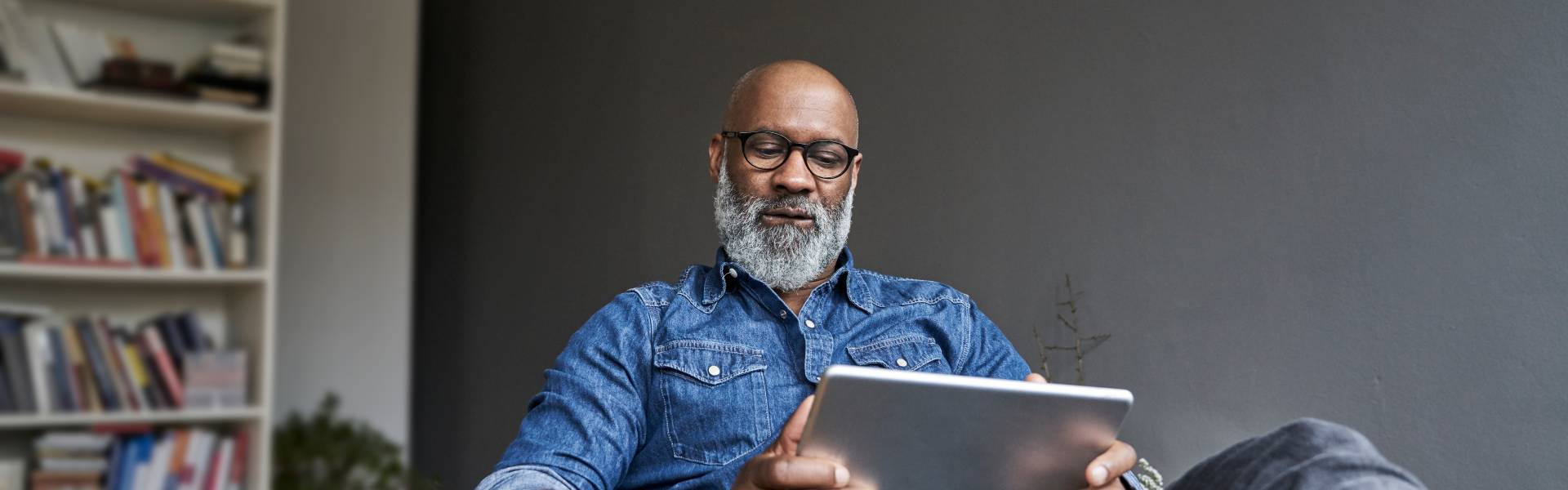 Image of a man searching online with a tablet device
