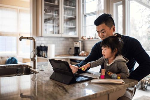 Dad and child on tablet in kitchen